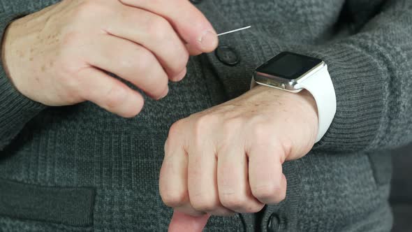 An Elderly Man Uses A Modern Smart Watch For Cashless Payments