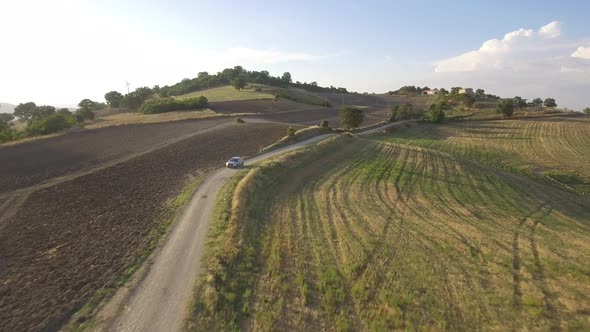 Drone view of a car driving in the countryside