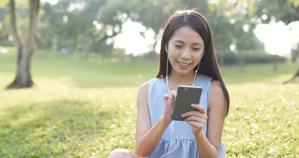 Woman watching on mobile phone at outdoor  alt