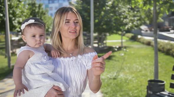 Joyful Mother and Baby Playing Bubbles Outdoors alt