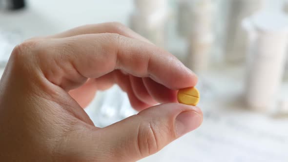 Yellow Medication or Pill in Male's Hand