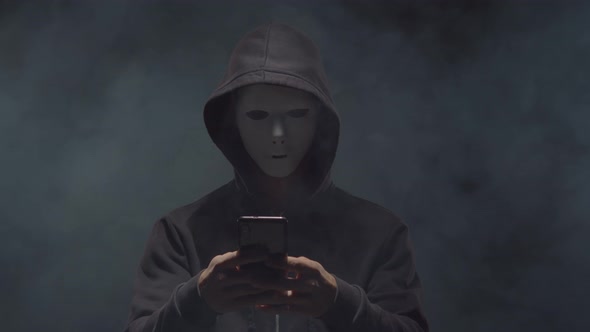 Portrait of computer hacker in hoodie. Obscured dark face. alt