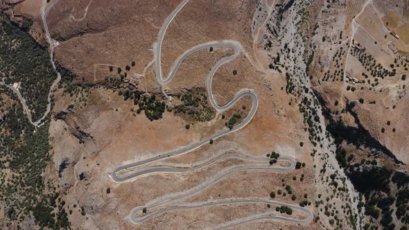 Flying over Serpentine road in the Greece, Europe. Flying above Deserted mountains.  alt