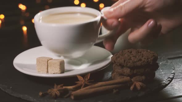 Woman Takes a Cup of Coffee and Drinks. Concept - Christmas, Cafe. Spiced Coffee alt