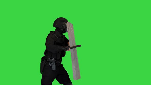 Riot Police Officer Hitting His Riot Shield While Moving Forward with the Shield Up on a Green alt