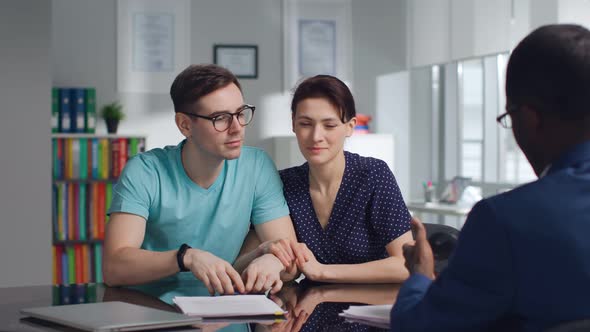 Happy Young Couple Pay Insurance Fees with Credit Card in Modern Office alt