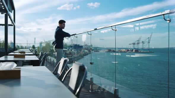 Millennial Guy Resting Terrace at Sea Port View alt