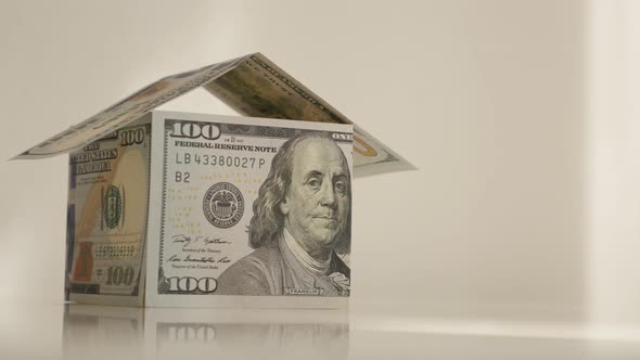 Tilting on dollar house on white background 4K 2160p 30fps UltraHD footage - USD paper currency made alt