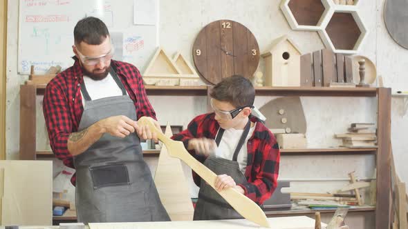 Little Male Woodworker Creating His Dream and His Dad Is Helping Him alt