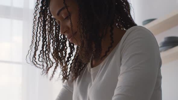 Close Up Below Portrait of Focused African American Woman Doing Something at Home Kneading Dough or alt