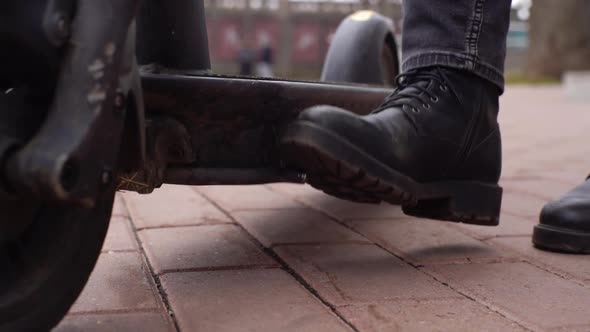 Closeup Legs of Unrecognizable Woman Putting Electric Scooter on Step of Modern City Street on alt