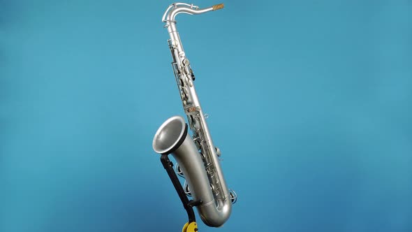 Rotating Wind Instrument Saxophone On Blue Background 1.