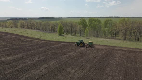 Tractor plows and cultivates the land alt