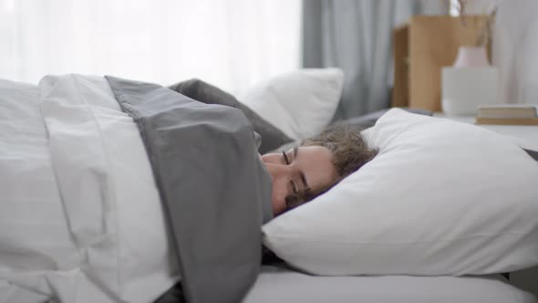 Attractive Woman Turning in Bed and Looking at Camera after Waking Up alt