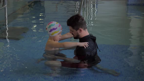 At the medical clinic Evexia in pool doctor checks how works feet of a little boy alt