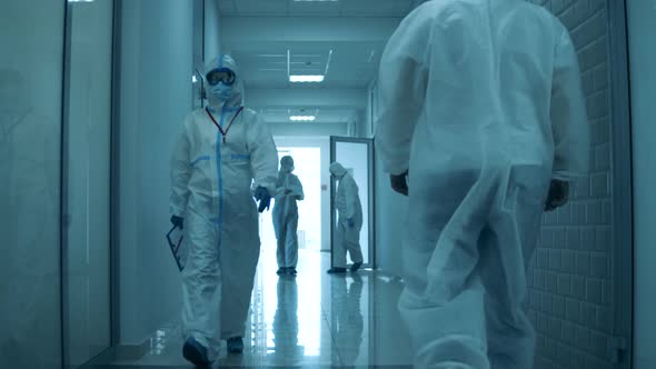 Many Doctors Work in Hospital During Coronavirus Pandemic, Walking in Hallway. alt