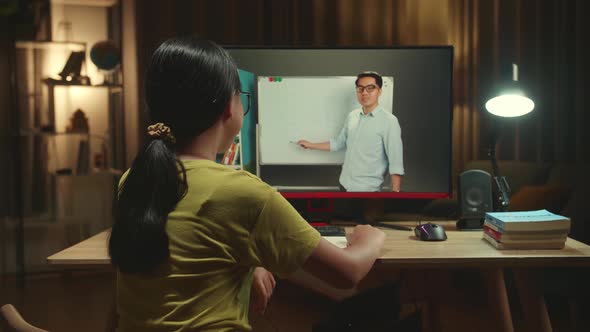 Asian Girl Student Distance Learning With Online Teacher On Computer Screen From Home alt