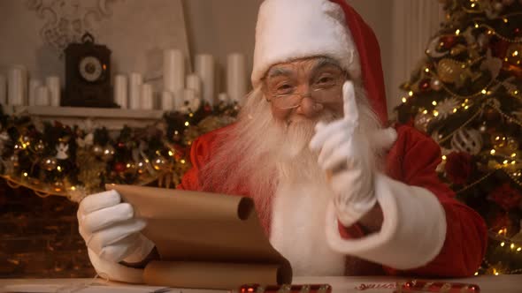 Santa Claus is Reading a List of Nice and Naughty Children in His Residence on North Pole Preparing alt