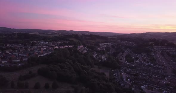 Aerial sideways dolly shot Aerial shot, colourful sunset over the suburbs of Exeter, England. alt