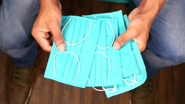 Top View of Man Hand Holding Surgical Face Mask alt