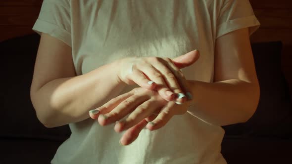 Middle Section of Young Pretty Woman in Casual Clothes Spreading Creme on Her Hands alt