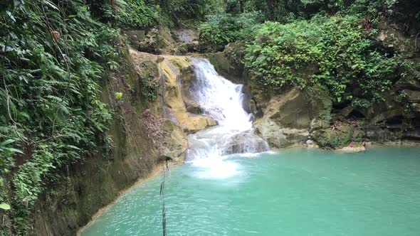 Incredible hidden Mag Aso Falls Philippine waterfall lagoon. Green water lagoon deep in the mountain alt