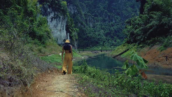 Cute Smiling Asian Girl Walking on a Trail in Cheow Lan Lake Thailand alt