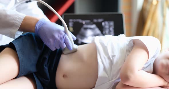 Doctor Conducting Ultrasound Examination of Kidneys to Child in Clinic Closeup  Movie alt