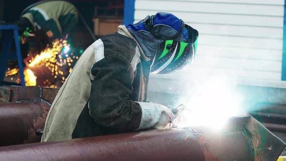 View of Welder Near Pipe at Work