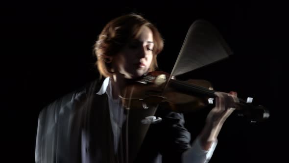 Violinist Performs a Violin in a Black Studio. Black Background alt