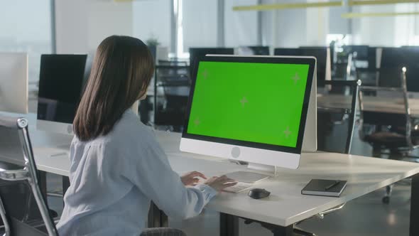 Business Multiethnic Woman Working on Desktop Computer with Green Screen Mock Up Display in Busy alt