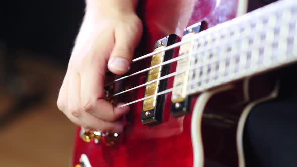 Closeup of a hand playing a bass guitar slapp style. Shot in 4K slow motion 60fps. alt