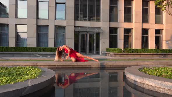 Beautiful Young Girl Dancing on the Street of a Modern City and Is Reflected in the Water. She Is alt