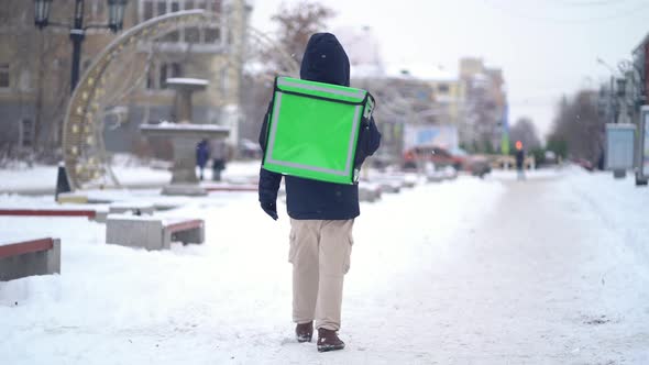 Courier Is Delivering Food with Backpack at Winter