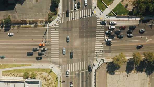 Top Down Aerial of Cars Driving By Cross Road Cityscape on Sunny Summer Day alt