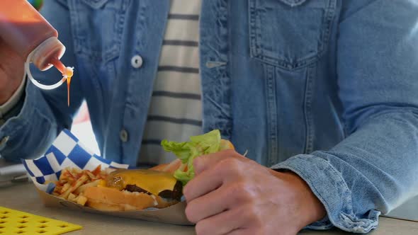 Man pouring sauce on french fries 4k alt