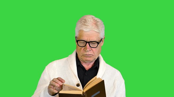 Senior Man Reading a Book on a Green Screen Chroma Key alt