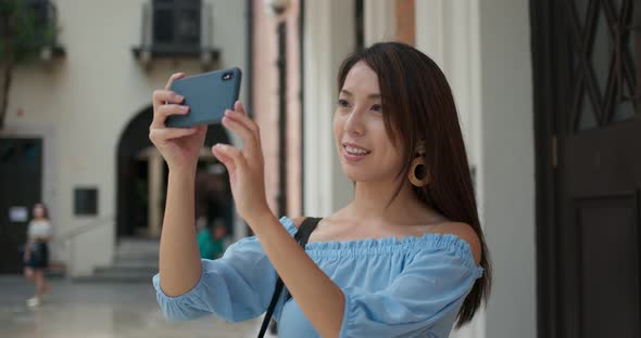 Woman tourist take photo on cellphone and visit old landmark in Hong Kong alt