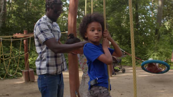 Children with father. Communication of families during a summer camp in forest.