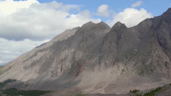 Mountains of Aktru valley with river and forest under white clouds in Altai