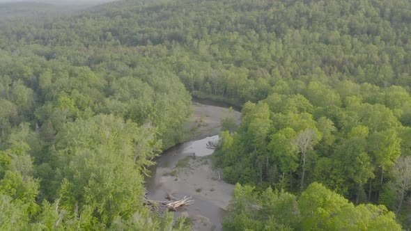 Aerial view flying over meandering river in the heart of nature alt