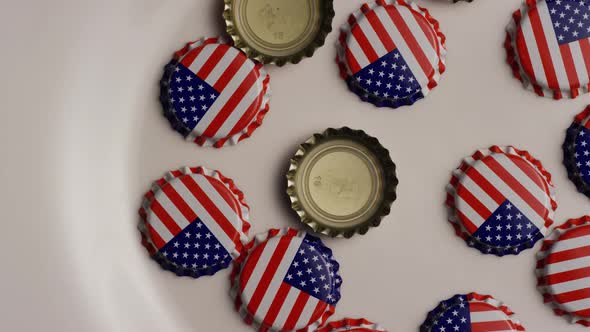 Rotating shot of bottle caps with the American flag printed on them  alt