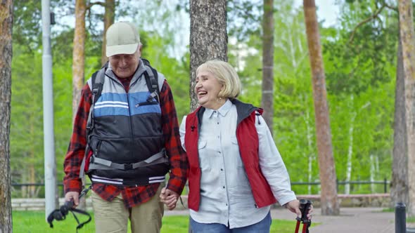 Elderly Couple Walking in Park alt