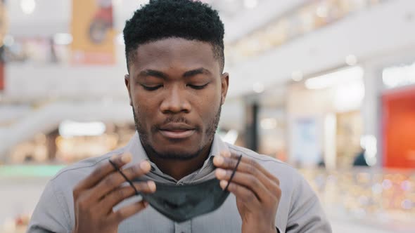 Closeup African American Man Taking Off Medical Mask From Face Breathing Deeply Feeling Relieved alt