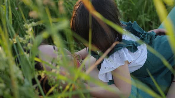 Koreans Family Mother and Daughter in Green Dresses Sitting in the Long Grass alt