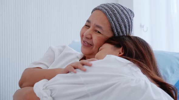 Young daughter encourages and comforts a mother with cancer during hospitalization. alt
