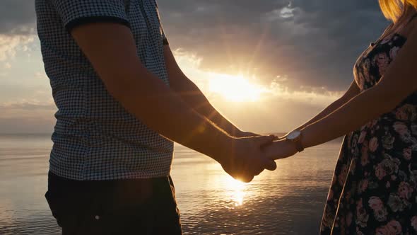 Couple Holding Hands at Sunset alt