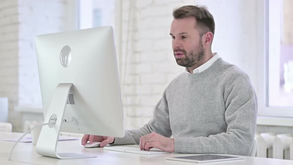 Tired Creative Man Sleeping While Working on Computer alt