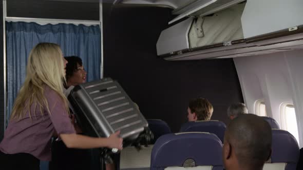 Flight attendant helping passenger with luggage