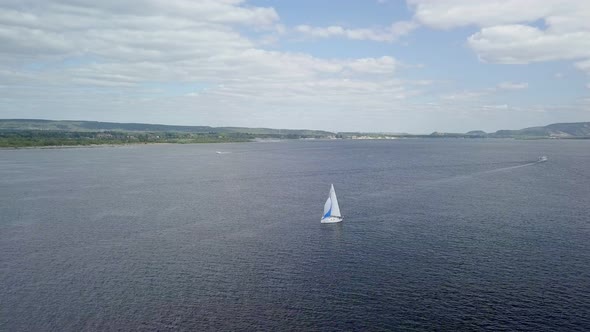 Aerial View on White Sailboat on River and Picturesque Clouds in Sunny Summer Day